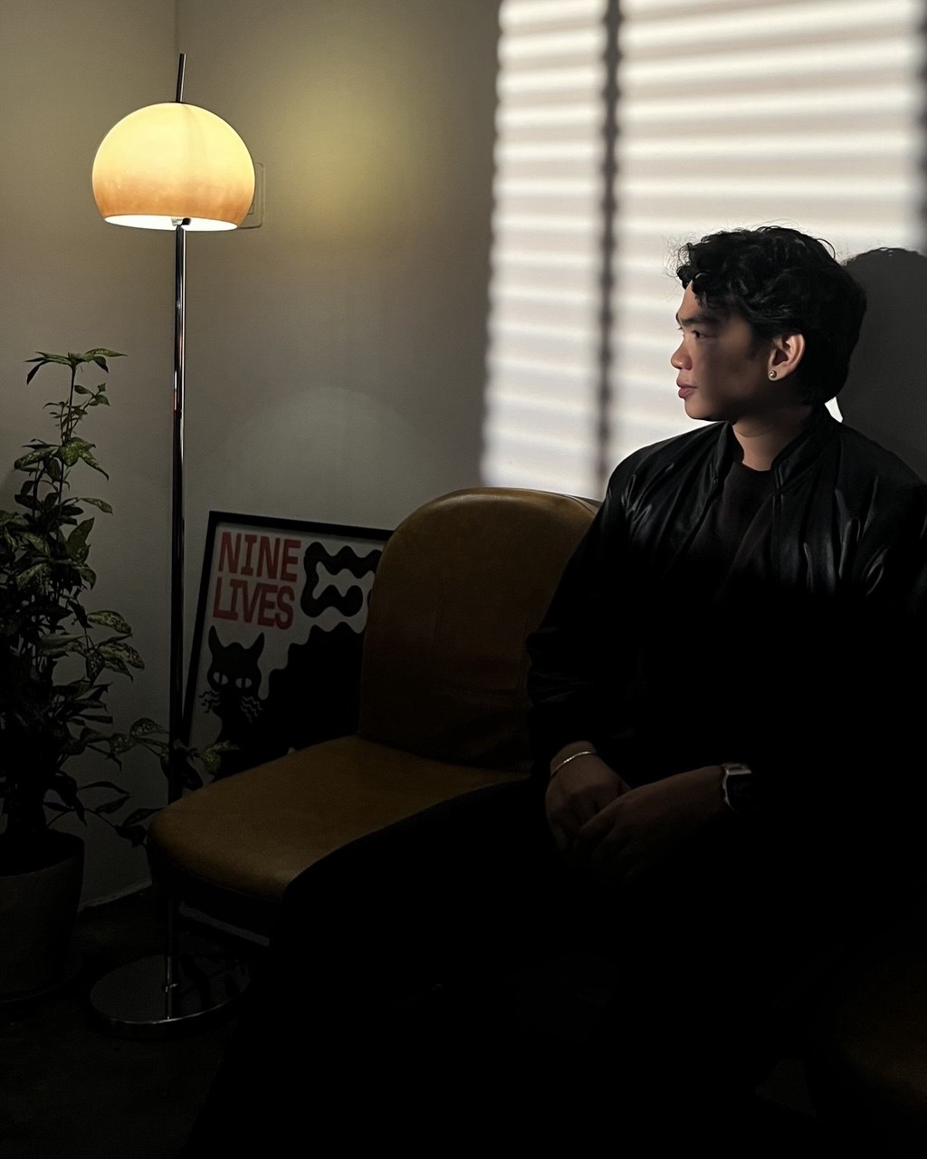 Ron Bañadera seated beside a warm lamp, looking to the side